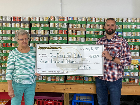 That’s a lot of groceries —Pictured are Joanne Anderson, representing the Cass County Food Pantry, and Chris Barrett, Cass County Division President for Petefish, Skiles & Co. Bank, with a check for the food pantry. (Photo provided.)