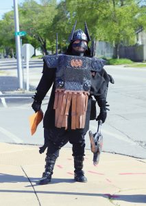 Social Distance Warrior –– “Nothing says ‘social distancing’ quite like an axe and a mask” says the sign being toted by the Medieval Batman warrior seen walking the streets of downtown Beardstown last Friday afternoon, May 8.