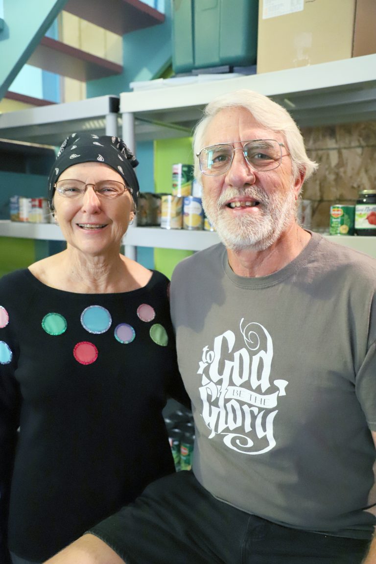 Volunteers – Triopia Food Pantry volunteers Linda and Wes Hendricker are pictured at the food pantry located at the Side Door in Arenzville.  Wes is a self-described “manager and the guy who writes the checks.” The Hendrickers also serve as a point of contact for anyone needing food pantry services. (Photo by Brian DeLoche)