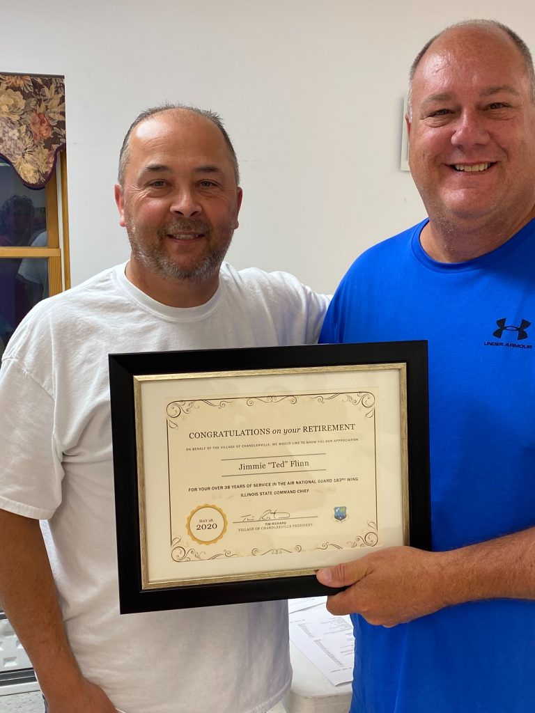 Following the Chandlerville Village Board meeting, Mayor Tim Richard, right, presents a plaque to Ted Flinn on his retirement from the Illinois National Guard 183rd Fighter Wing after 38 years of service. Flinn retired as the Illinois State Command Chief.