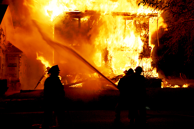 Beardstown firefighters redirect their water streams from the vacant burning house to the home at 406 E. 3rd Street in the attempt to save the house next door.  The two homes were separated by a distance of just a few feet, allowing heat and burning embers to ignite a fire in the attic space of the neighboring home.  No injuries were reported in the fire which remains under investigation by local authorities and the office of the State Fire Marshal.				       (Photo by Brian DeLoche)