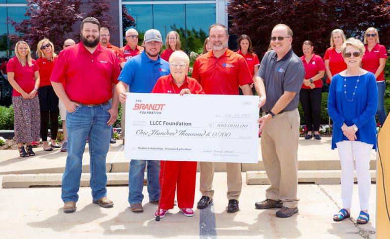 Evelyn Brandt Thomas (center) presents a check for $100,000 from The Brandt Foundation to the LLCC Foundation to support agriculture education. L-R: Logan Williams, LLCC ag alum and Brandt employee; John Sudduth, current LLCC ag student; Evelyn Brandt Thomas; Rich Teeter and Bill Harmon, LLCC professors of agriculture; Dr. Charlotte Warren, president of LLCC. In the background are Brandt employees.