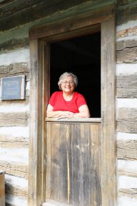 Volunteer extraordinaire — Debby Krohe of Virginia is pictured at the Dutch door of a cabin at Rexroat Prairie, one of the many projects to which she devotes her time. (Photo by Brian DeLoche.)
