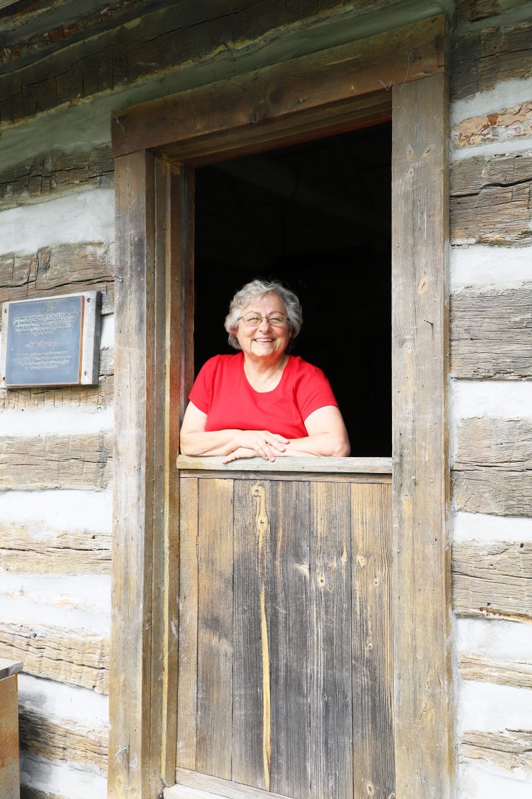 Volunteer extraordinaire — Debby Krohe of Virginia is pictured at the Dutch door of a cabin at Rexroat Prairie, one of the many projects to which she devotes her time. (Photo by Brian DeLoche.)