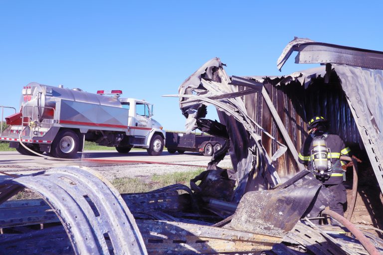 Hitting the hot spots — A Virginia volunteer firefighter hoses down hot spots inside what is left of a semi-tractor trailer destroyed in a fiery crash on Illinois Route 125 last Thursday morning.  Three people suffered non-life threatening injuries as a result of the near head-on crash. Route 125 was completely closed for nearly four hours, forcing traffic to be re-routed.  One lane traffic was still reported as late as 9 p.m. as crews worked to clear the crash scene. (Photo by Brian DeLoche