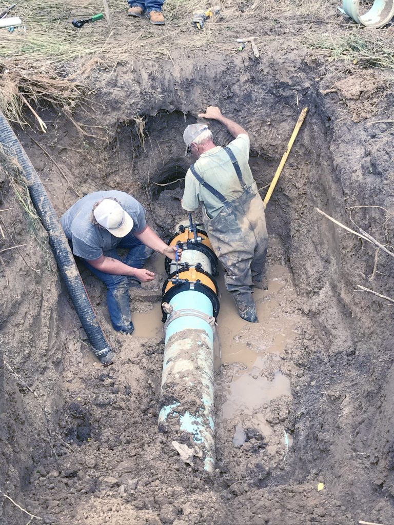 Dillon Cook, left, an employee of the Virginia Water District, and Randy McClure, water superintent for CRWD, work on repairs following a water line break.
