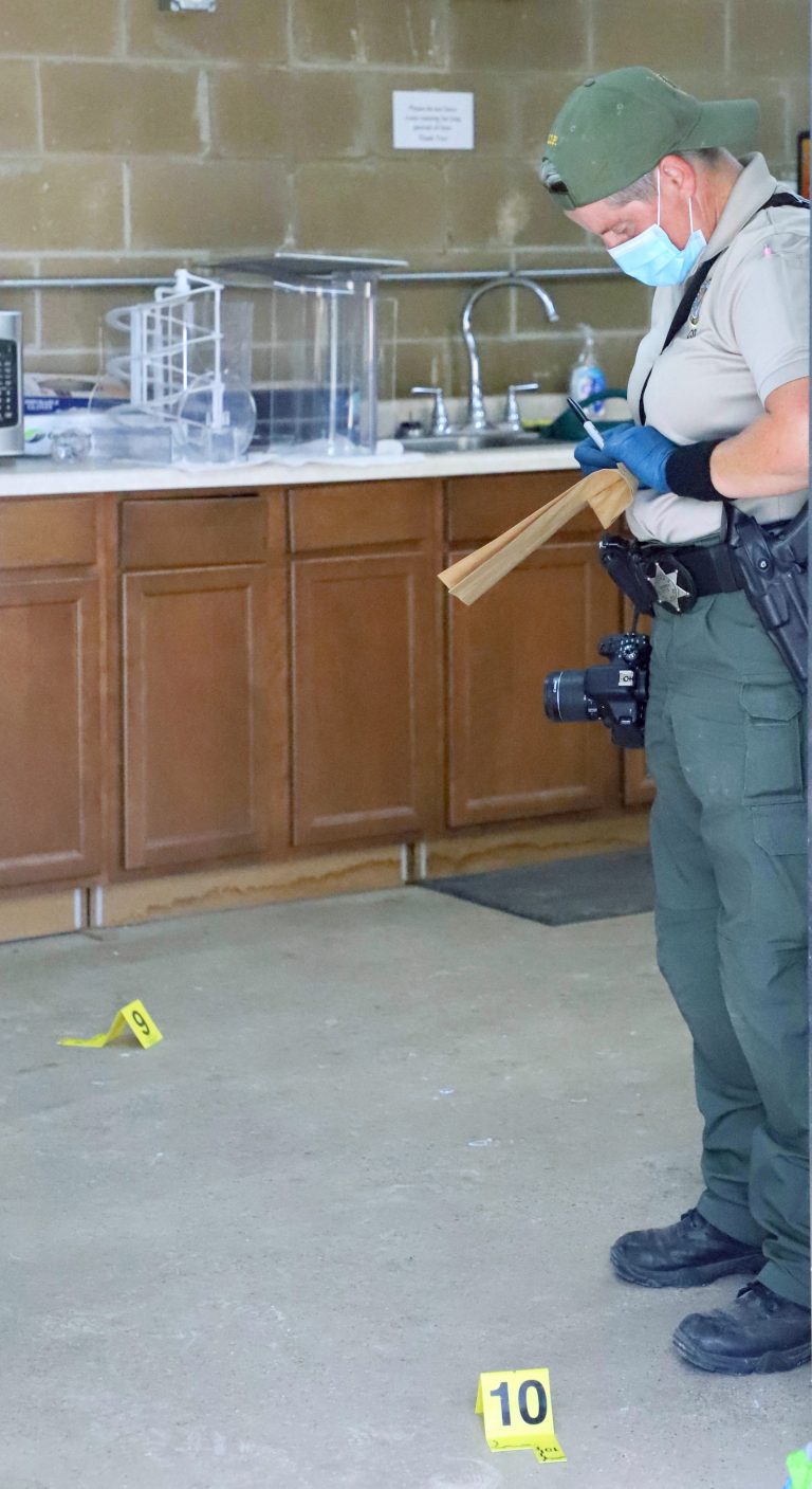 Processing the scene — Trooper  Field, crime scene investigator for the Illinois State Police, records evidentiary notes while processing the scene of a break-in at the Little League concession stand at Schmoldt Park. (Photo by Brian DeLoche.)