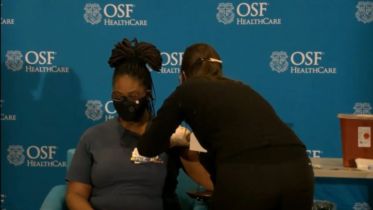 Chemica Jones, 41, a certified nursing assistant, receives one of the first COVID-19 vaccines administered in Illinois during an event Tuesday at OSF St. Francis Medical Center in Peoria. (Credit: blueroomstream.com)