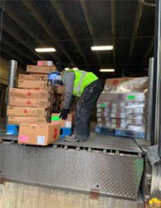 A JBS employee loads packages of meat on a pallet for delivery to the Cass County Food Pantry for distribution with the pantry’s December food boxes.