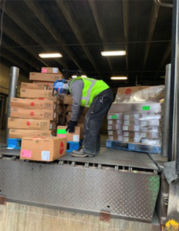 A JBS employee loads packages of meat on a pallet for delivery to the Cass County Food Pantry for distribution with the pantry’s December food boxes.