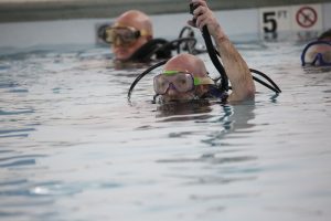 Beardstown Dive & Recovery Team member Travis Mathews resurfaces after spending several minutes seated on the bottom of the indoor pool at the Rushville Fitness & Community Center.