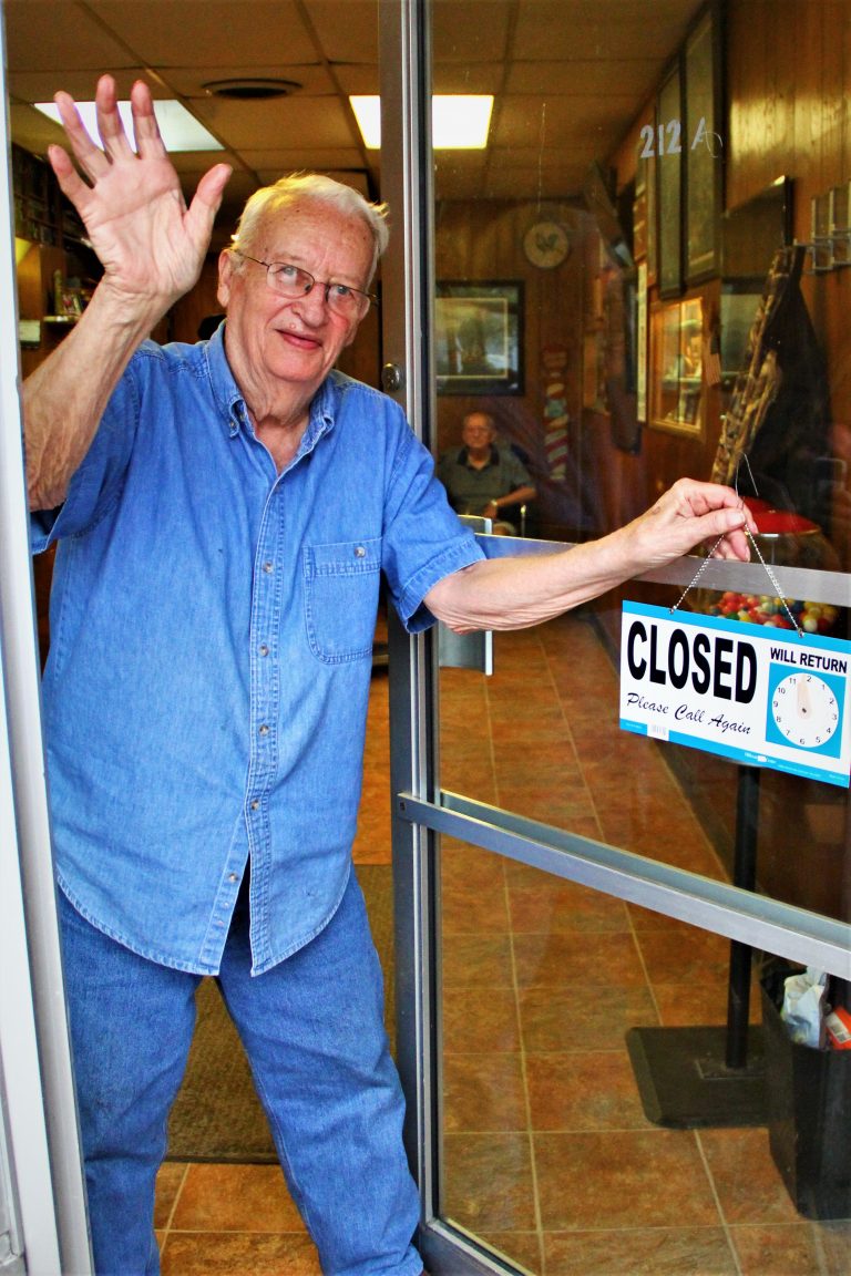 Local historian, two-time author, barber, story-teller and all around good guy, Harold Tyson is shown putting out his closed sign and locking the door for the final time after 67 years on the job. Photo by David V. Miller