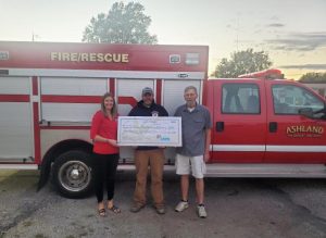 CMFB Secretary Jenny Ring presents $3,500 to Ashland Fire Protection District Chief Tyler Latham and Ron Aggert.
