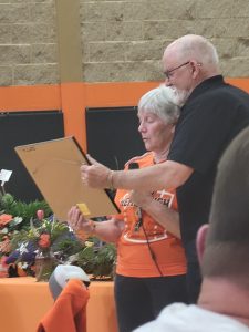 John Heriford presents a plaque to Sue Hembrough during a Celebration of Life for her husband, Bob Hembrough, on Saturday. The celebration for the beloved Beardstown coach, who among other honors, was inducted into both the Illlnois Basketball Coaches Association Hall of Fame and the Illinois Football Coaches Association Hall of Fame, was held at the Beardstown High School gym.	    Photo by Nick Krohe