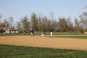 Tiger senior shortstop William Davidsmeier opts to go to first for the out as Owen Quigley covers second base and a Triopia Trojan slides in safely in Beardstown’s 8-7 win.   Photo by Jason Brockschmidt