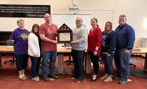 Matt Eveland presented a flag that flew over Kuwait on 9/11/2021 to the Virginia School District in honor of his time as a Redbird. Pictured left to right: Stephanie Hobrock, Beth Cox,  Matt Eveland, Casey French,  Kara Lynch,  Joanie Bell, Gary Bell. 	Photo by Val Pratt