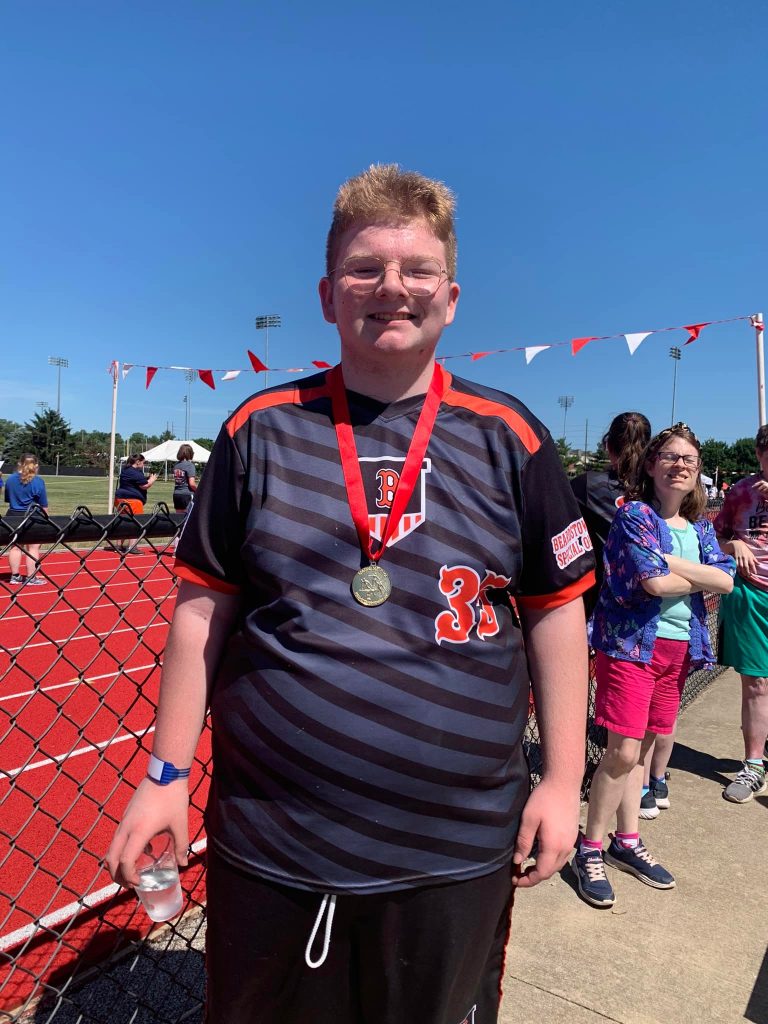 C.J. Evans is all smiles with a Gold Medal around his neck for taking 1st Place in the softball throw at the Special Olympics of Illinois Summer Game.