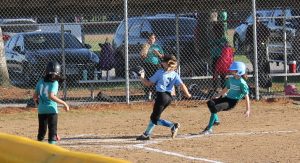 Jenna Durham of Tyson’s Diner slides into home ahead of the throw on a passed ball versus Beardstown Savings in Minor League Girls softball play.