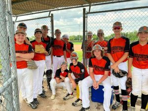 The Beardstown Junior League All Stars try to give the camera the game face but fail and break into smiles while waiting in dug out during Sub State play in Oglesby.