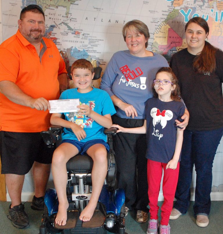 Tim Krause (left) presenting check to Kurtus. To his left is Billie Brunk, Lily and Abby Brunk.