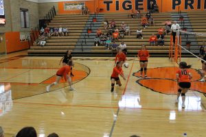 Jazmin Pacheco Grillasca makes the dig as her teammates look on intently in JV volleyball action.
