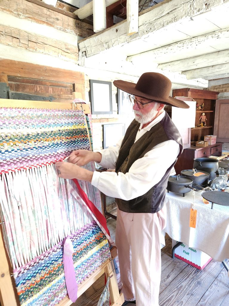 Above, a volunteer demonstrates how to hand make a rug in the Rexroat Cabin (Photo by Jaime Chapman)