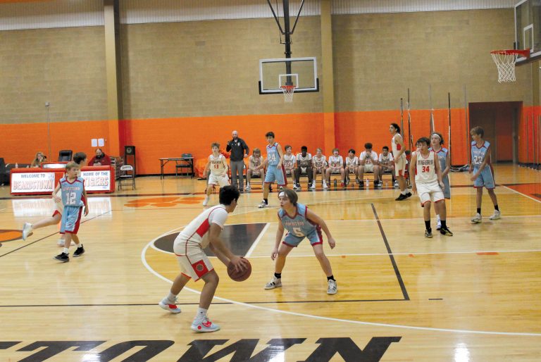 At the right, Josh Camas of the Beardstown Junior High Tigers jab steps his defender while Ryan Shaw (#34) breaks open in the lane in junior high basketball versus the Lewistown Junior High Indians.