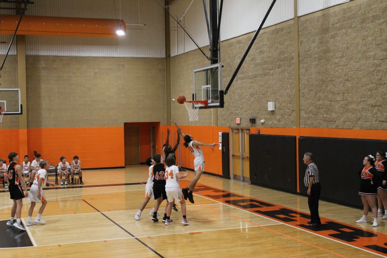 Vincent Sweeney of the Tigers leaps high for a rebound in a junior high basketball game against Macomb.