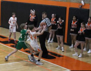 Colby DeSollar of the Tigers battles a Brown County Hornet for the ball in the final home game of the season for junior high basketball.