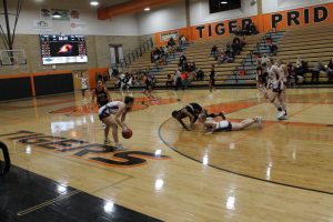 “All out effort!”  In a typical scene at the Lady Tiger Classic, Bertille Kayembe of Beardstown and a Mendon Unity Mustang sell out for the ball and crash to the floor.