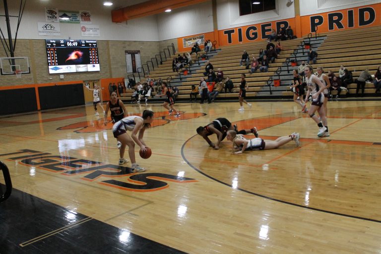 “All out effort!”  In a typical scene at the Lady Tiger Classic, Bertille Kayembe of Beardstown and a Mendon Unity Mustang sell out for the ball and crash to the floor.