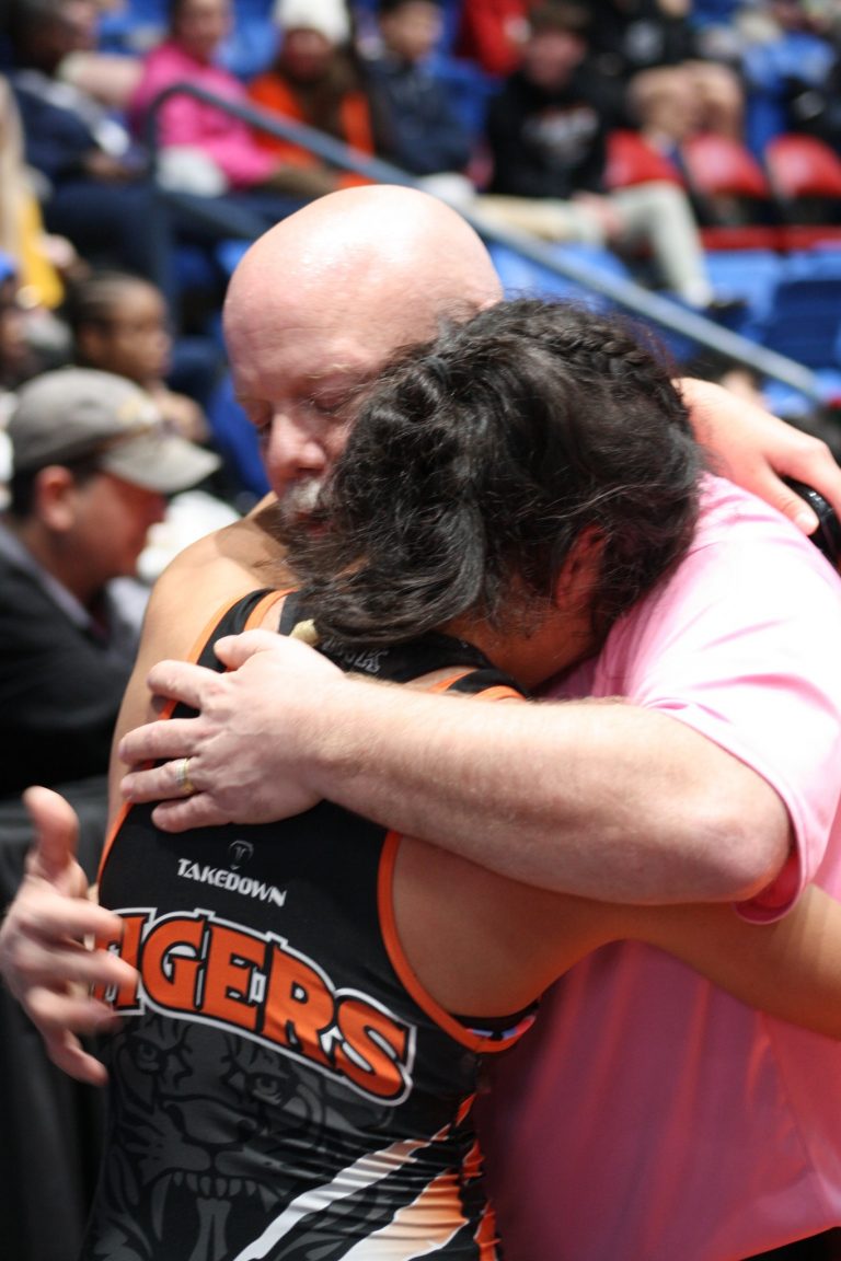 Tiger Freshman wrestler Daisy Gil and Coach Joe Kolb share a hug following Gil’s season ending loss at the IHSA Girls Wrestling State Finals.