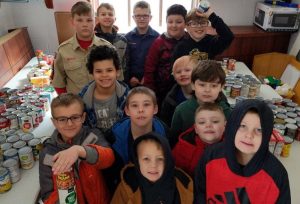 Cub Scout Troop 125  along with some of the food they collected for the Cass County Food Pantry. Pictured, front to back,  Aiden Coyle, Leland Sisti, Mathew Sisti, Casey Myers, Ryne Fox, Wyatt, Andy Miller, James Wallis, Kylen Snedecker, Michah Coyle, Kayden Snedecker, Zacarias Dugay, and Camden Myers.