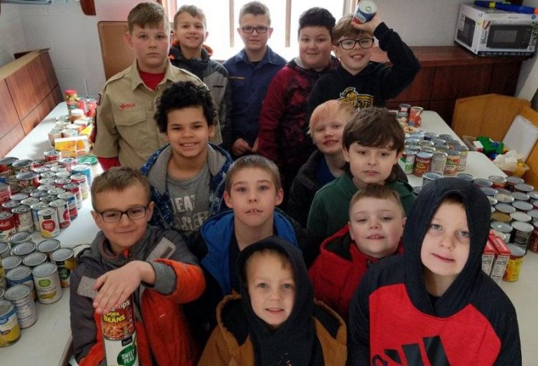 Cub Scout Troop 125  along with some of the food they collected for the Cass County Food Pantry. Pictured, front to back,  Aiden Coyle, Leland Sisti, Mathew Sisti, Casey Myers, Ryne Fox, Wyatt, Andy Miller, James Wallis, Kylen Snedecker, Michah Coyle, Kayden Snedecker, Zacarias Dugay, and Camden Myers.