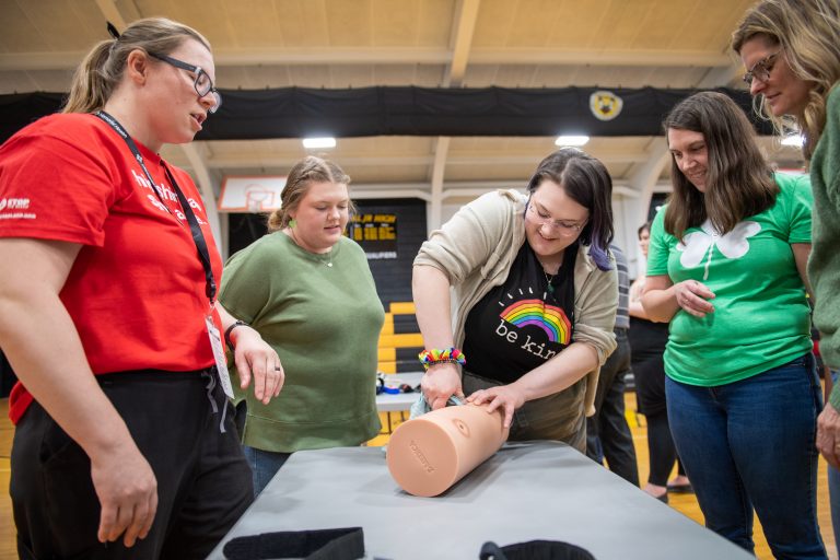 Ashley Olson, a nurse in the Springfield Memorial Hospital Emergency department, shows a group of teachers from A-C Central High School how to apply pressure to an open wound during a recent Stop the Bleed class at the school.