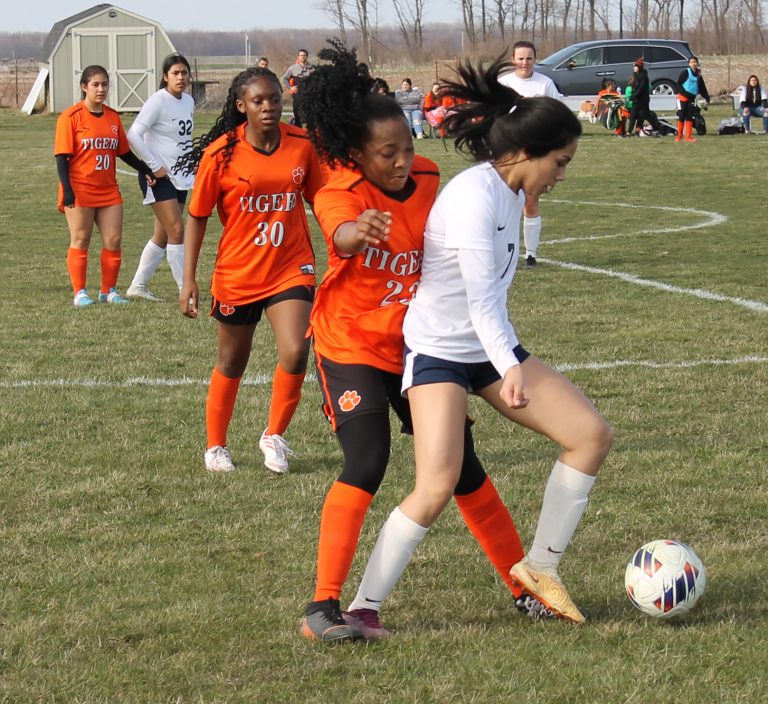 Davina Kanda of the Lady Tigers battles a Monmouth-Roseville Titan for the ball in girls varsity soccer action.
