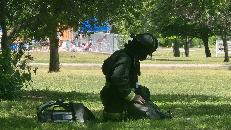A firefighter sits in the shade after exiting the Parkside Apartments. With tempatures around 90, heat related illness is a major concern to the men and women battling fires.  Photo by Jaime Chapman