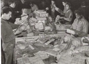 Members of the 6888th sorting mail, assisted by French volunteers