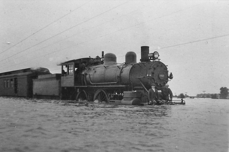 A westbound Baltimore & Ohio train wades through flood waters just east of Beardstown in 1926, a reminder of what can happen with the Illinois River goes on a rampage. (CIPS Photo, Leigh Morris collection)