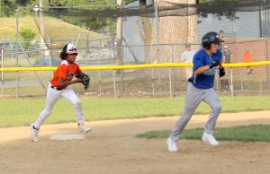 The Twins DeWade Gaffney gives chase to the Bluejays Evan Brewer in Little League baseball action.