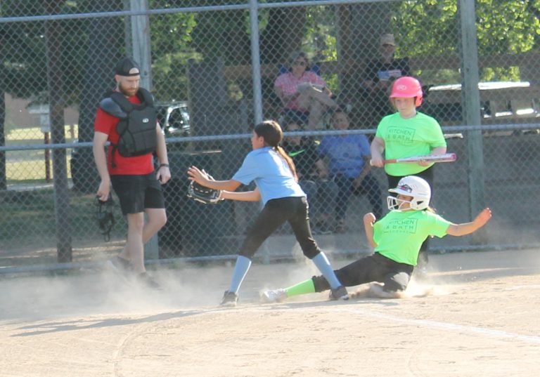 Safe!  The runner beats the throw and scores on a passed ball in Little League girls softball action.