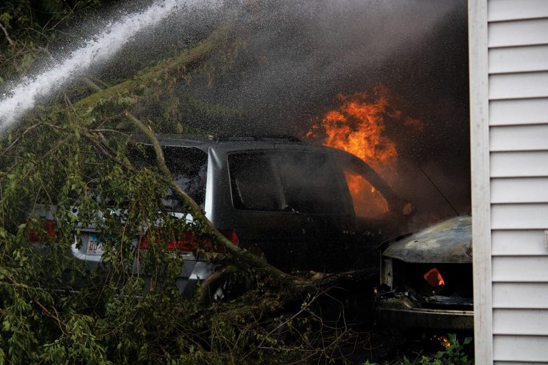 Spray from a fire hose work to extinguish a van engulfed in flames.                  Photo by Kaitlyn Copley