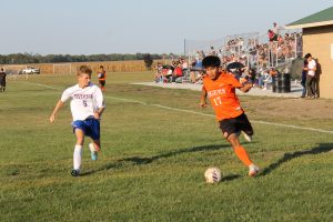 A nice crowd fills the new bleachers in the background at the Park District soccer field as Luis Rios is on the attack for BHS.