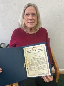 Ann Chelette is pictured holding the Senate Resolution in honor of her father, Roy Roberts