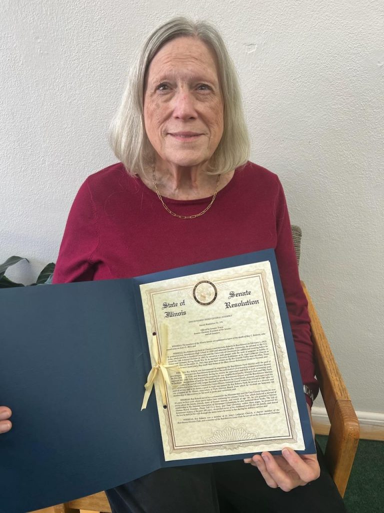 Ann Chelette is pictured holding the Senate Resolution in honor of her father, Roy Roberts