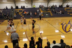 Ashley Gil launches a three-pointer in front of an excited Tiger bench.