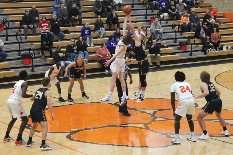 The Tiger’s Rylan Alhorn goes high to win the tip against Camp Point Central.