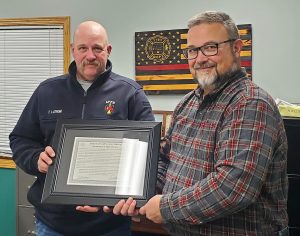Outgoing Ashland Fire Chief Tylor Lathom, left, receives a resolution of appreciation approved by the Ashland Fire Protection District Board.