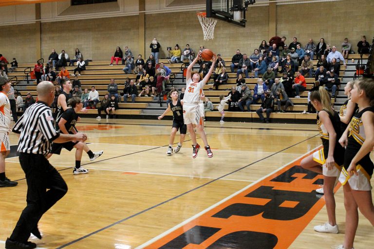 Ripping down a rebound for the Tigers is Carsen Hammack in a junior high hoops game.