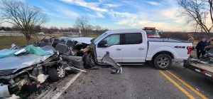 A truck has a car pinned against the guardrail. Photo by Beardstown Volunteer Fire Department.